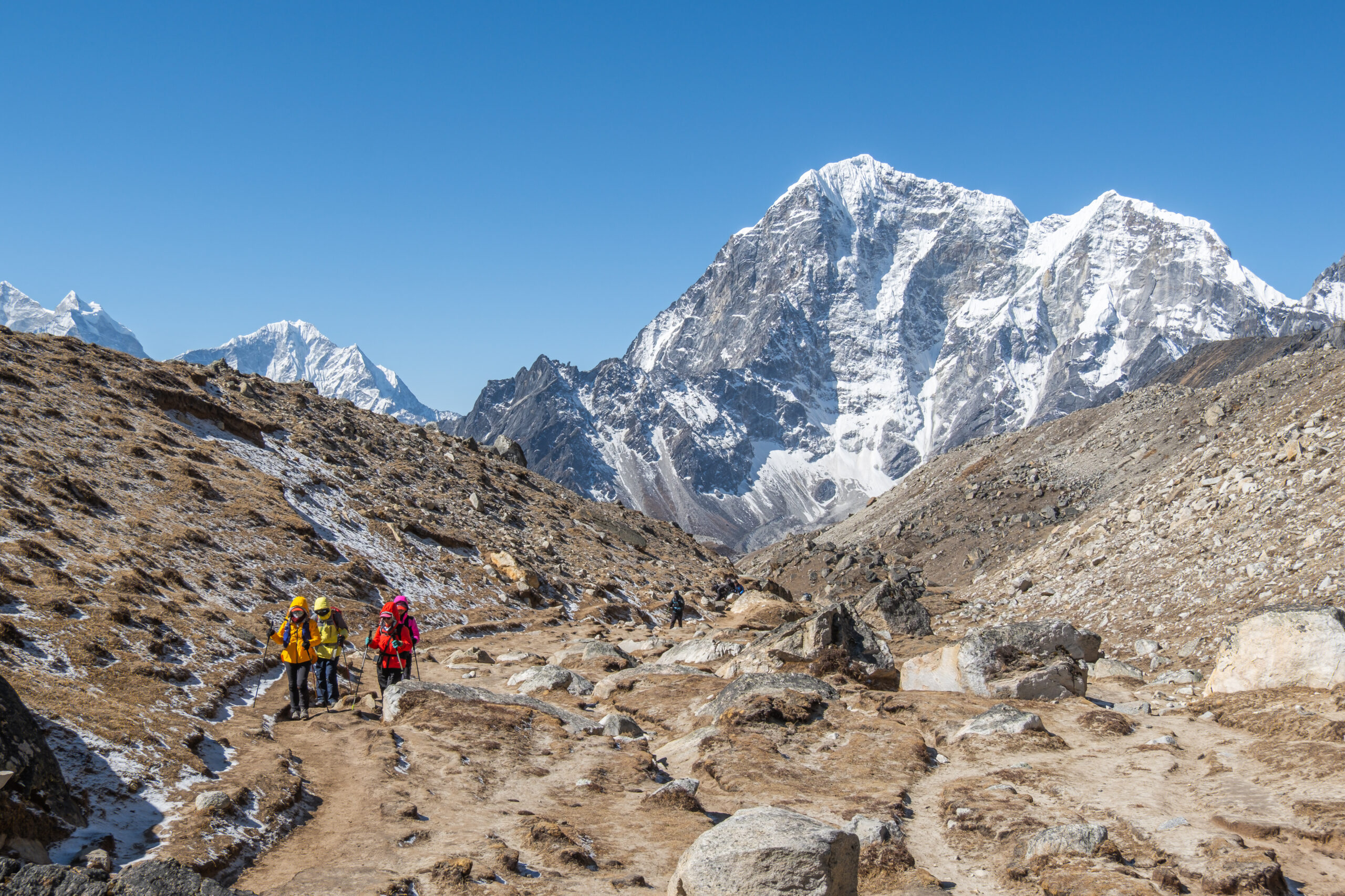 Tourist and porters walking on dirt road in Nepal to Everest Base Camp